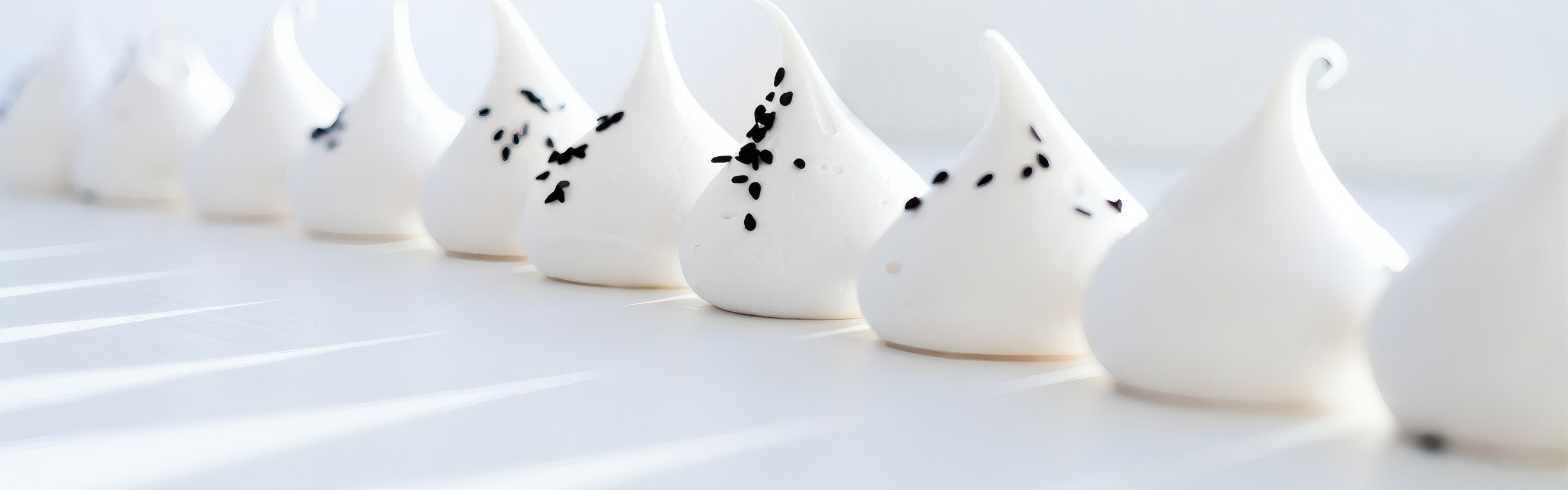 A row of meringue kisses on white