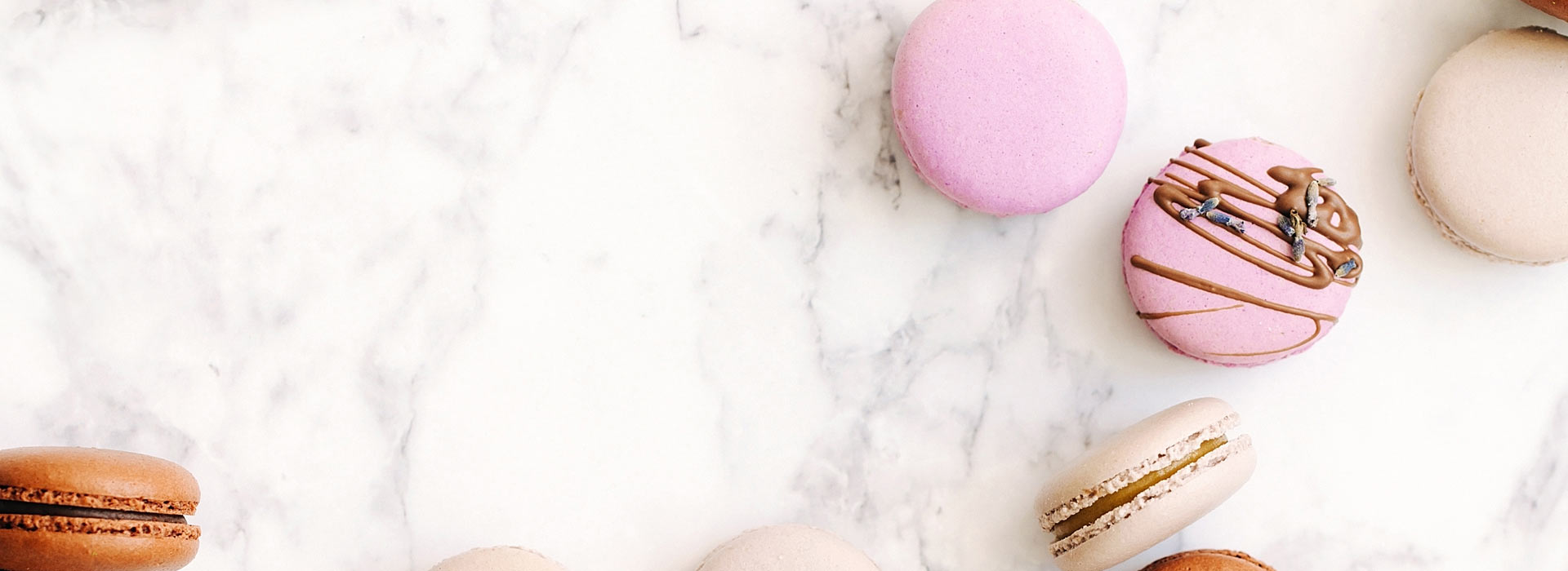 Macarons scattered on white marble