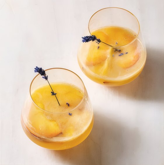 Two glasses of an orange aperitivo with lavender