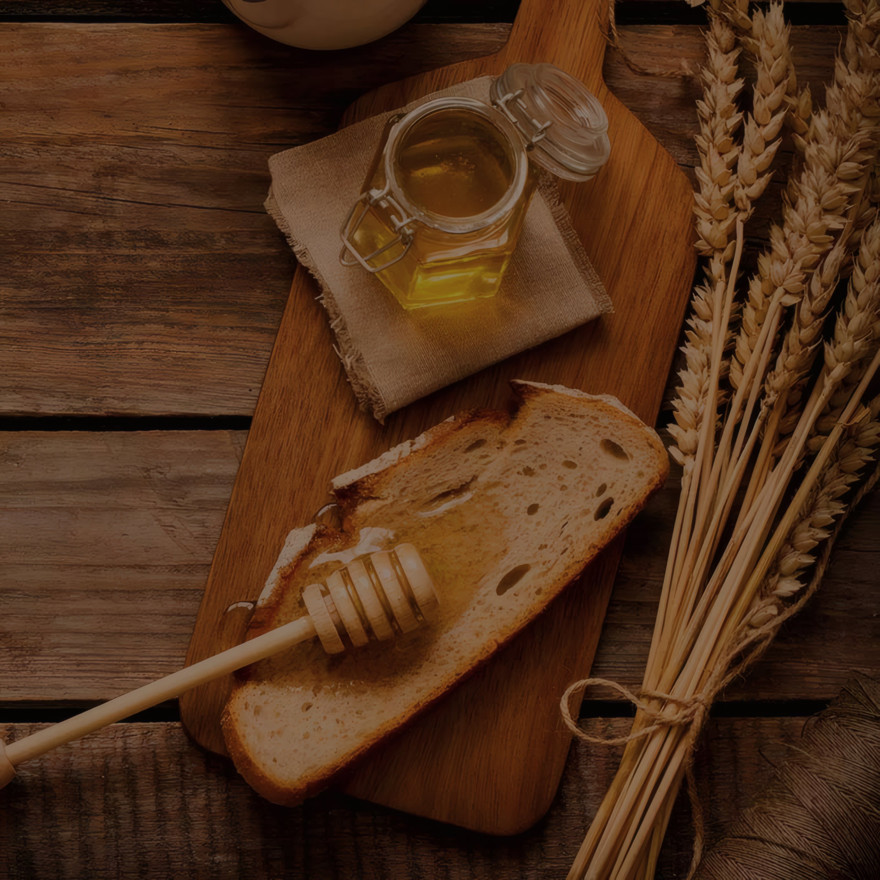 Bread, honey and wheat on a wooden board