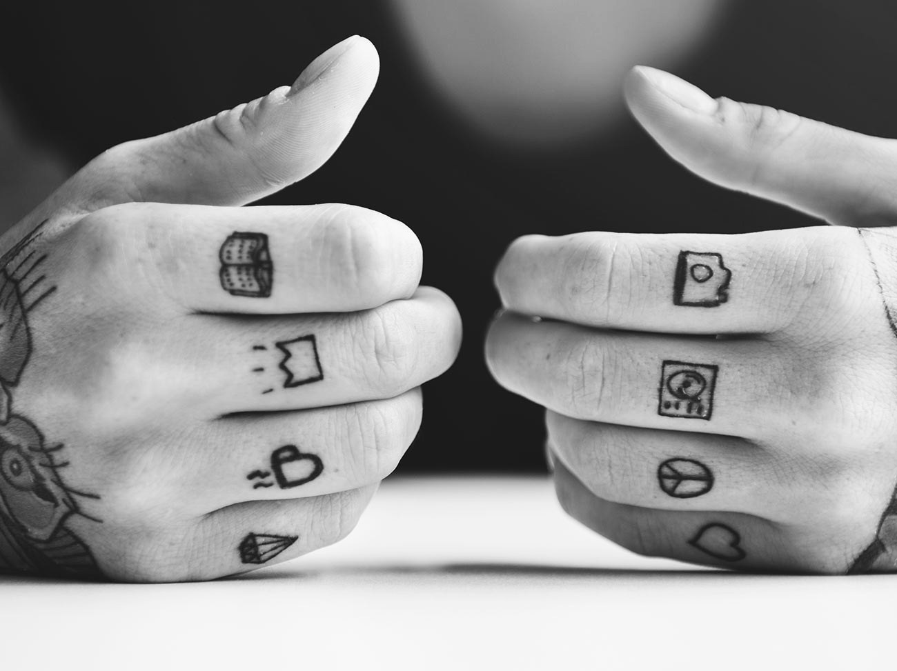 Small flash tattoos across the knuckles