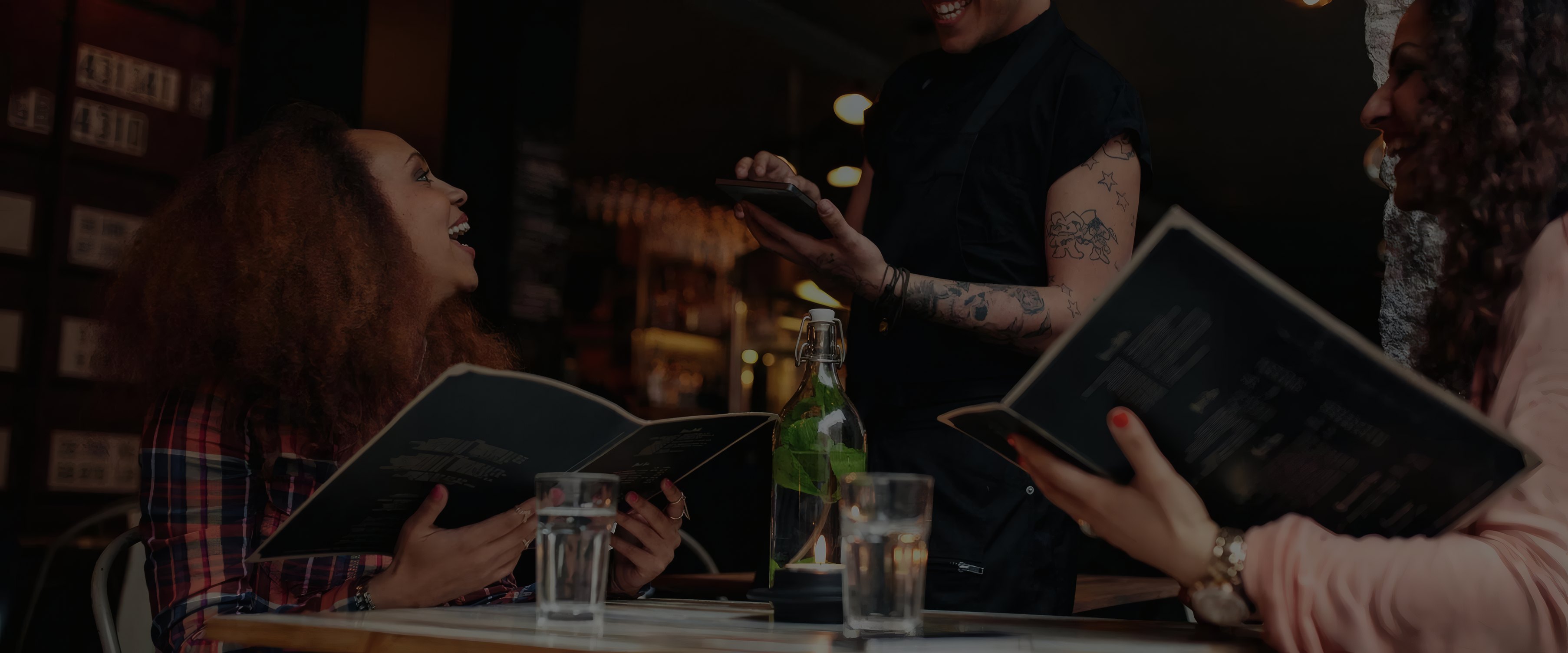 Friends reading the menu at the bar