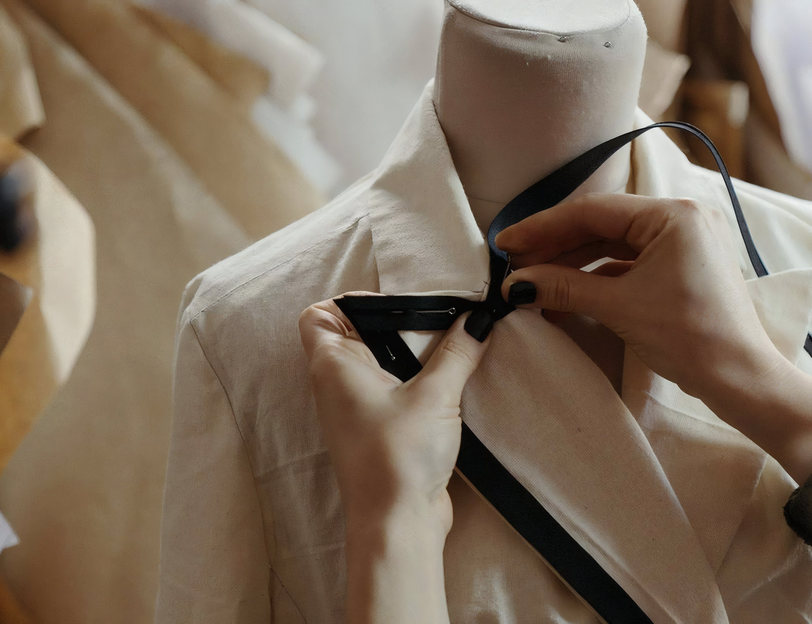 Hands pinning the lapel of a jacket on a dress form
