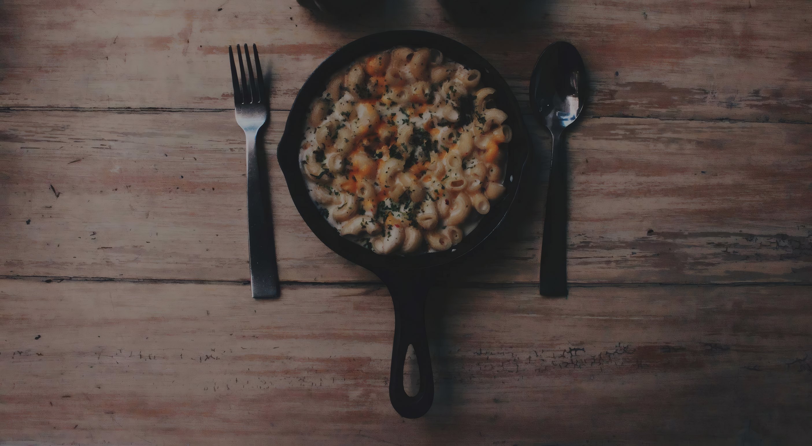 Baked rigatoni in a skillet on a wooden table