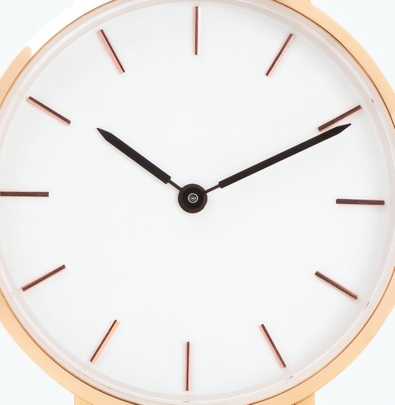 The white dial of a rose gold watch, close up