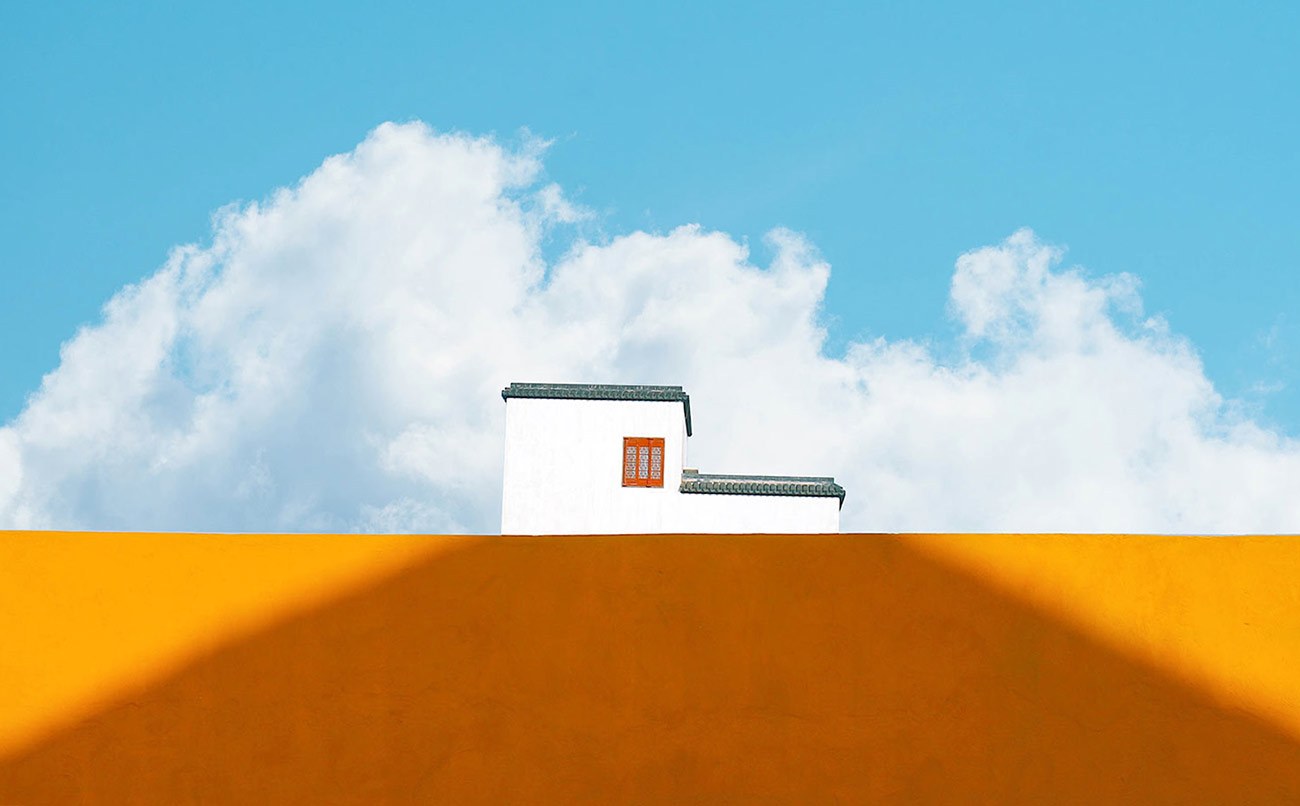 A white house above an apricot wall