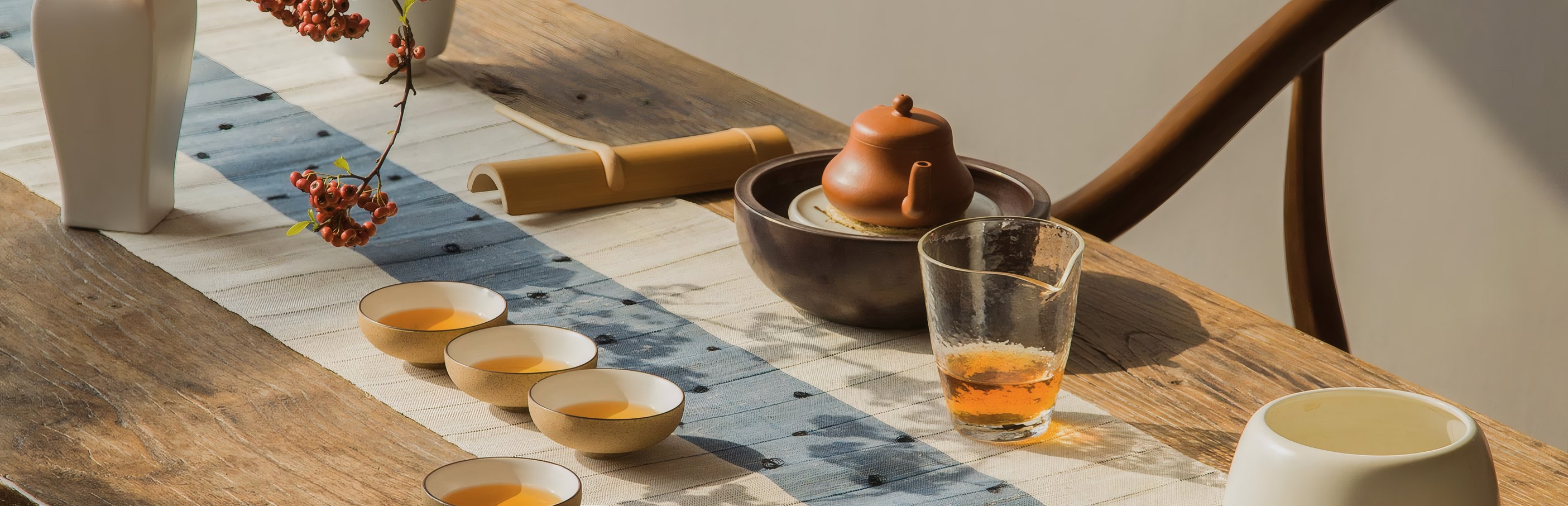 A tea table set with cups, a clay pot and a jug