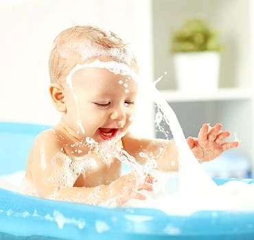 Baby splashing in a paddling pool