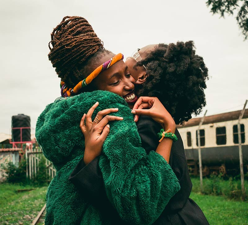 A mother and child hugging in green knits