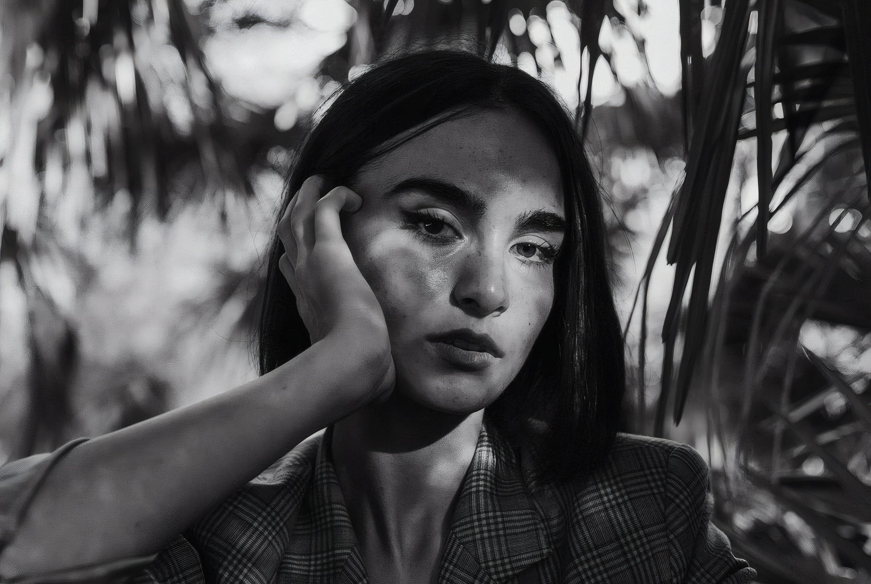 A portrait among palm leaves, in black and white