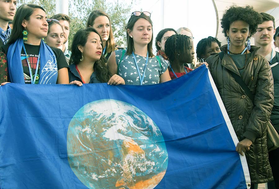 A climate march behind an earth flag